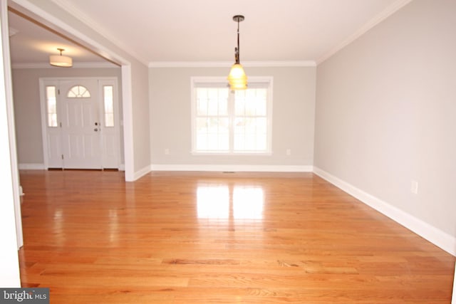 entrance foyer with light wood-type flooring, baseboards, and crown molding