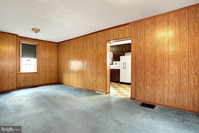 carpeted spare room featuring ornamental molding, visible vents, and baseboards