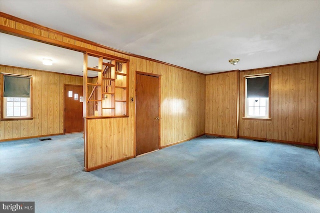 unfurnished room with baseboards, visible vents, stairs, crown molding, and carpet floors