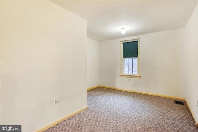 empty room with carpet floors, baseboards, and visible vents