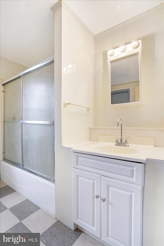 bathroom featuring tile patterned floors, enclosed tub / shower combo, ornamental molding, and vanity