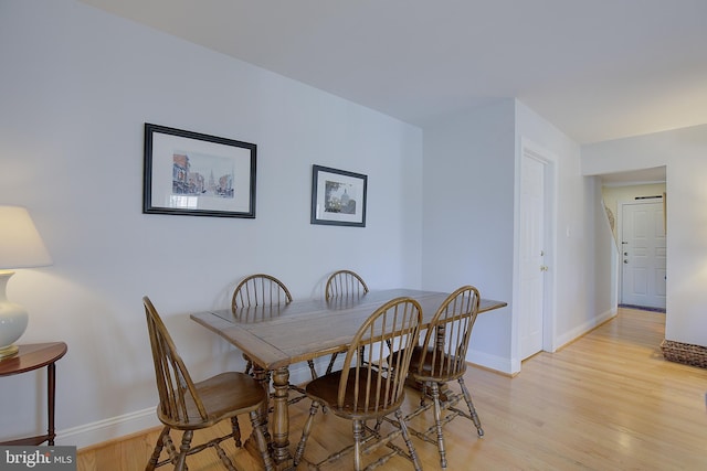 dining space featuring light wood-style floors and baseboards