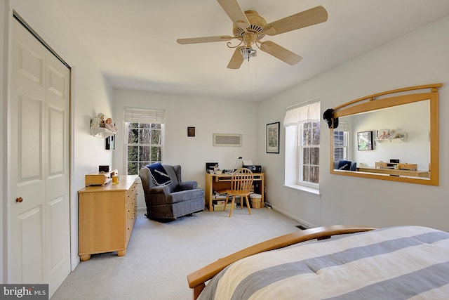 bedroom with visible vents, a ceiling fan, and light colored carpet