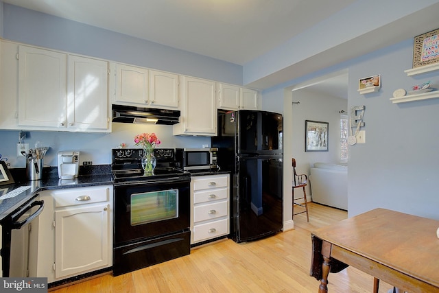 kitchen featuring dark countertops, white cabinetry, light wood-type flooring, under cabinet range hood, and black appliances