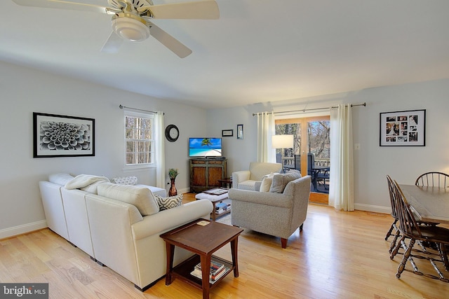 living room with light wood-type flooring, a wealth of natural light, and baseboards