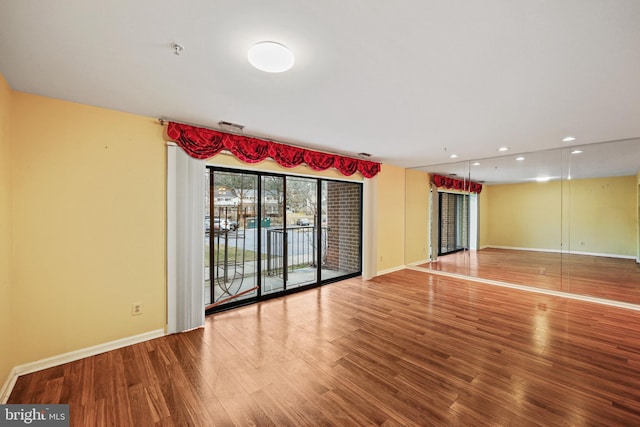 unfurnished room featuring recessed lighting, visible vents, baseboards, and wood finished floors