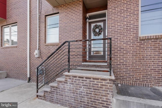 entrance to property featuring brick siding