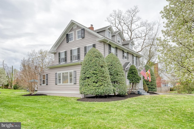 view of home's exterior with a chimney and a yard