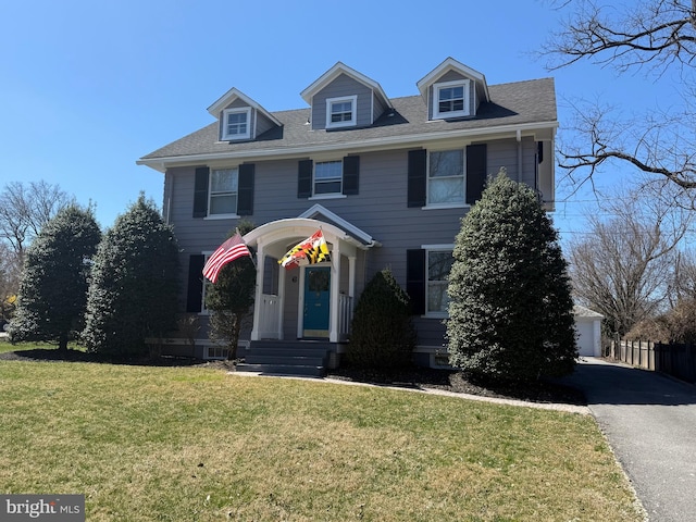 view of front of property featuring a front yard, a garage, and fence