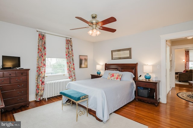 bedroom featuring ceiling fan, wood finished floors, and radiator