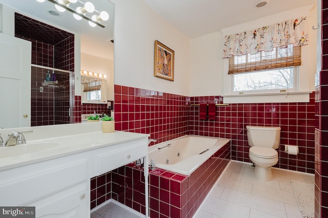 full bathroom with vanity, tile walls, toilet, tile patterned floors, and a jetted tub