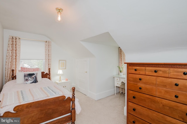 bedroom featuring light carpet, baseboards, and vaulted ceiling