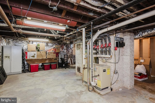 unfinished basement featuring white fridge with ice dispenser