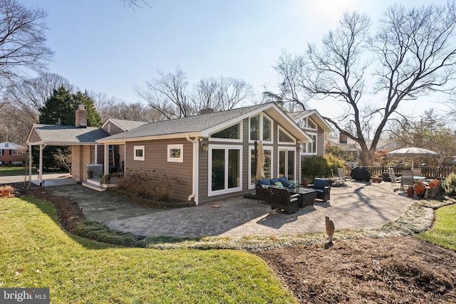 rear view of house featuring a shingled roof, a lawn, an outdoor hangout area, a chimney, and a patio