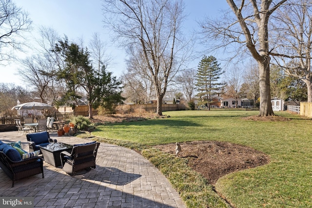 view of yard featuring an outbuilding, a storage shed, a patio, and fence