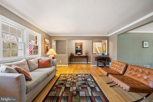 living room with baseboards, visible vents, ornamental molding, and wood finished floors