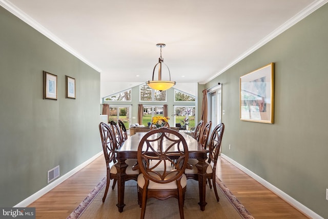 dining area with visible vents, crown molding, baseboards, and light wood-type flooring