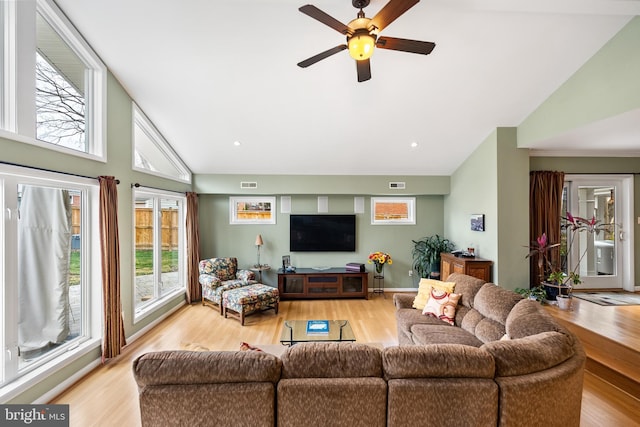 living room with visible vents, ceiling fan, light wood-style flooring, and high vaulted ceiling