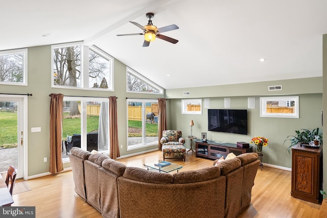 living area with visible vents, high vaulted ceiling, light wood-style flooring, and a ceiling fan