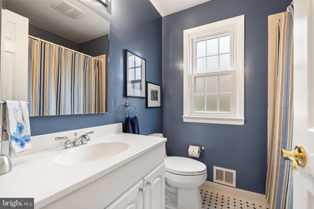bathroom featuring baseboards, visible vents, toilet, and vanity