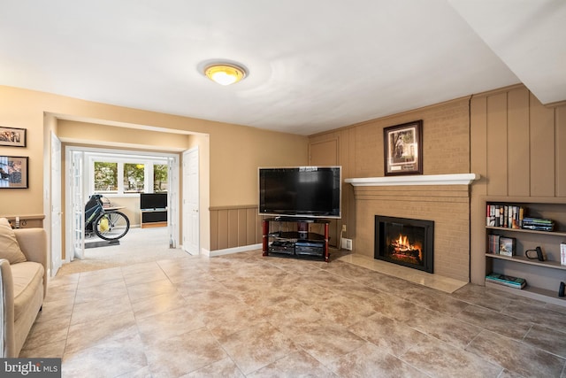 living area featuring a wainscoted wall and a fireplace