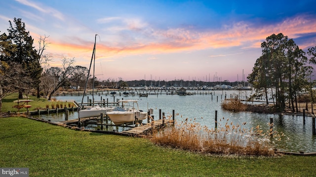 view of dock with a lawn, a water view, and boat lift