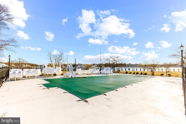 view of swimming pool featuring a patio area, a fenced in pool, fence, and a water slide