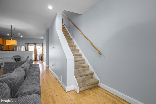 interior space featuring light wood-style floors, visible vents, stairs, and baseboards