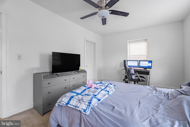 bedroom featuring light carpet, a ceiling fan, and baseboards