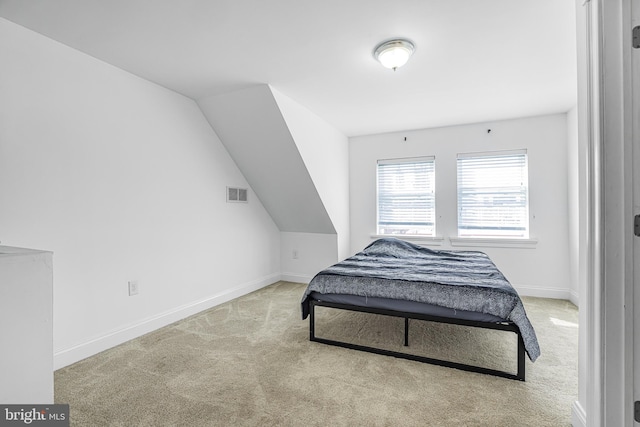 bedroom with lofted ceiling, carpet, visible vents, and baseboards