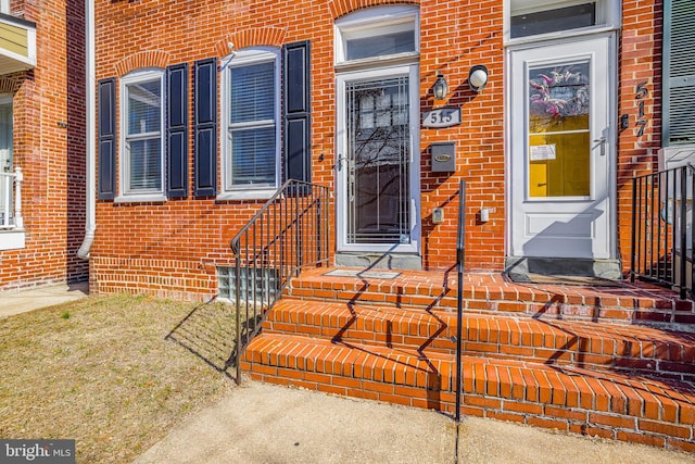 doorway to property featuring brick siding