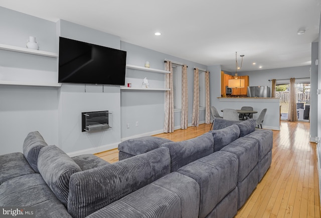 living room featuring baseboards, recessed lighting, and light wood-style floors