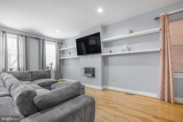 living area with recessed lighting, wood finished floors, visible vents, and baseboards