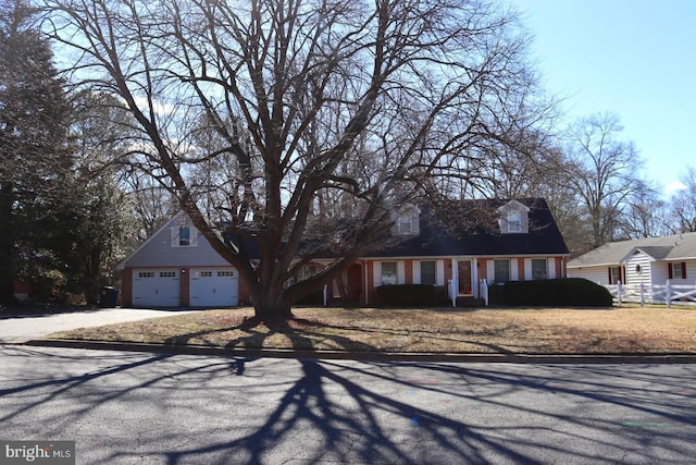 cape cod home with a garage and concrete driveway