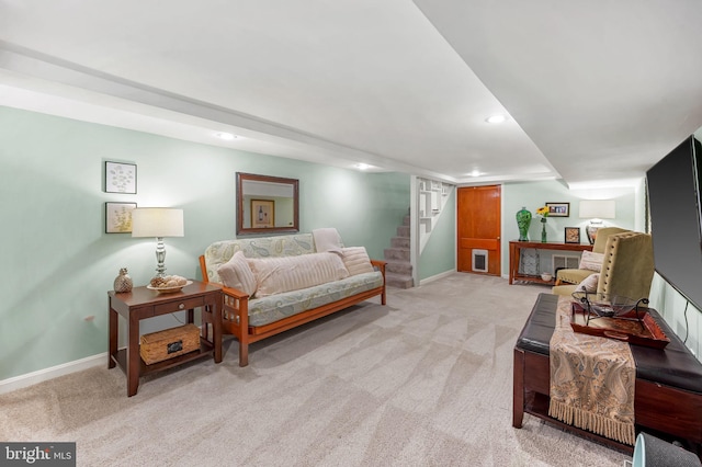 living room with baseboards, stairway, and light colored carpet