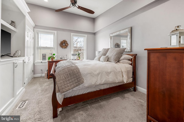 bedroom with baseboards, visible vents, and light colored carpet