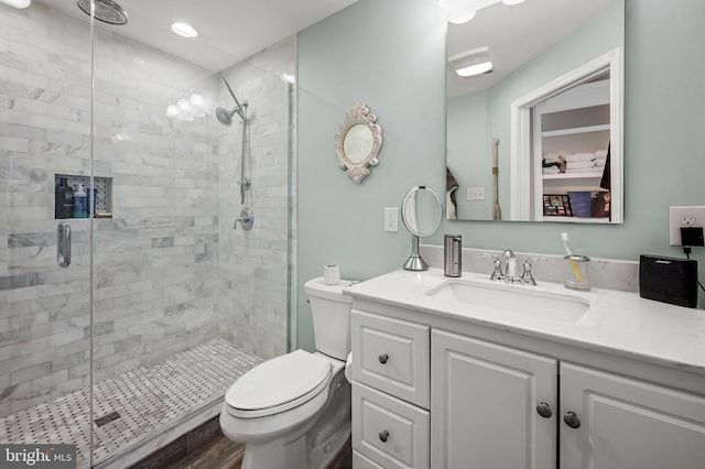 full bathroom with a stall shower, vanity, and toilet