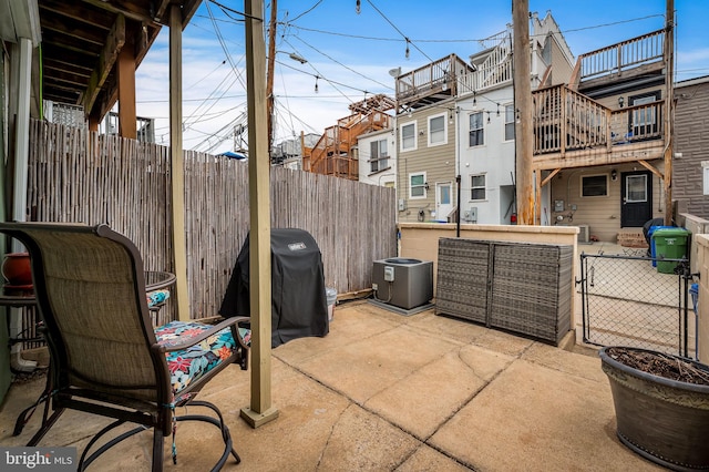 view of patio / terrace with area for grilling, fence, and a residential view