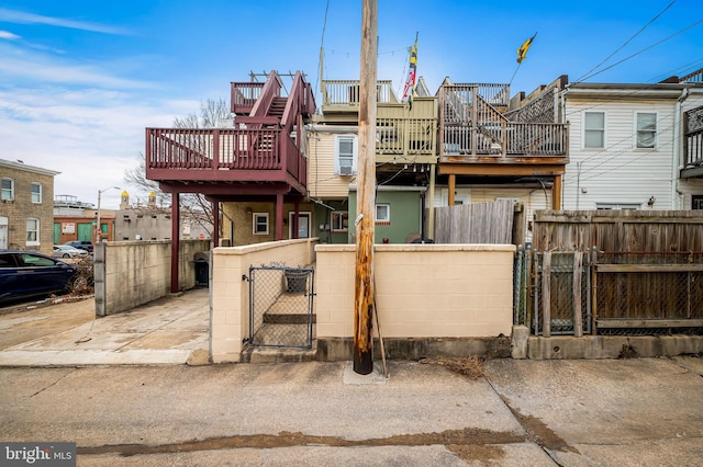 view of front of property with a fenced front yard, a gate, and a wooden deck