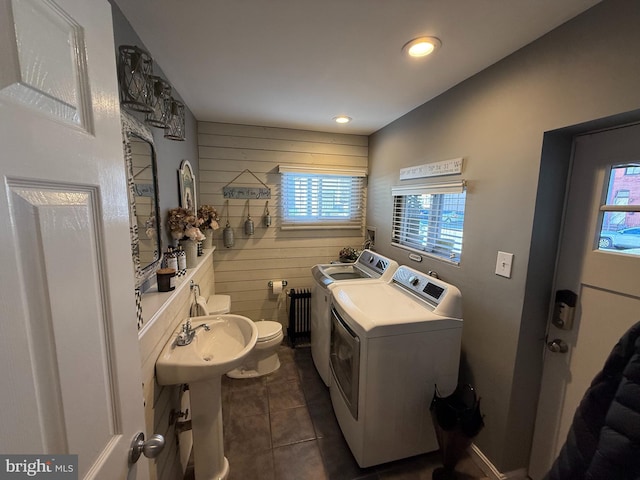 laundry area featuring recessed lighting, laundry area, separate washer and dryer, wood walls, and dark tile patterned flooring