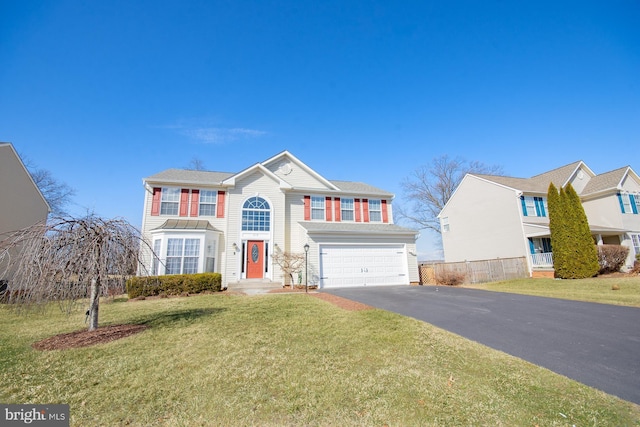 view of front facade with aphalt driveway, a front yard, fence, and an attached garage