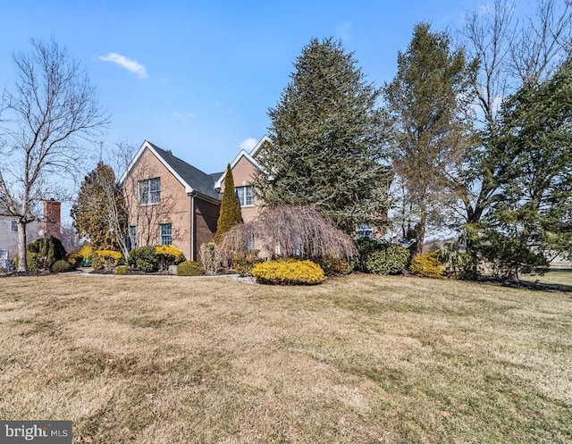 view of front of property featuring a front lawn and brick siding