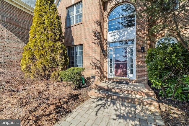 property entrance featuring brick siding