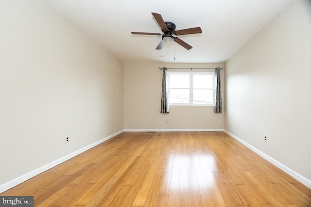 spare room featuring light wood-type flooring, ceiling fan, and baseboards