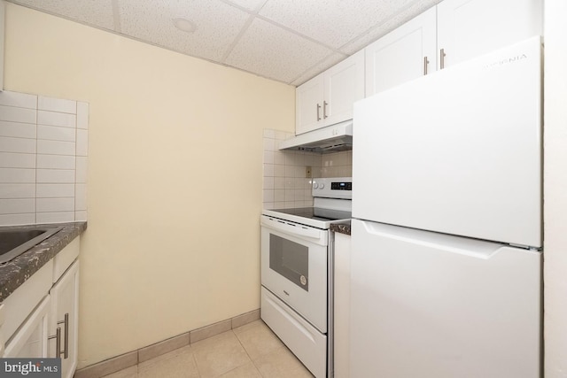 kitchen with white appliances, light tile patterned floors, white cabinets, decorative backsplash, and under cabinet range hood