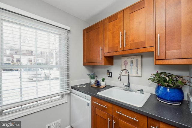 kitchen with a healthy amount of sunlight, white dishwasher, visible vents, and a sink