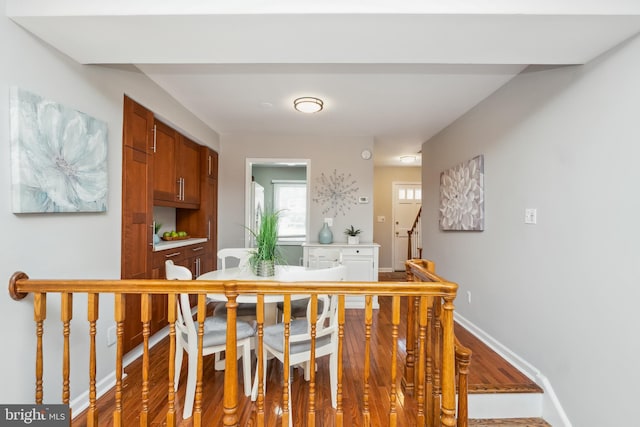 corridor with baseboards and wood finished floors