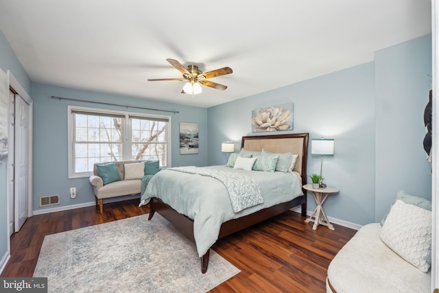 bedroom with a closet, wood finished floors, visible vents, and baseboards