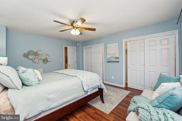 bedroom with ceiling fan, baseboards, multiple closets, and wood finished floors