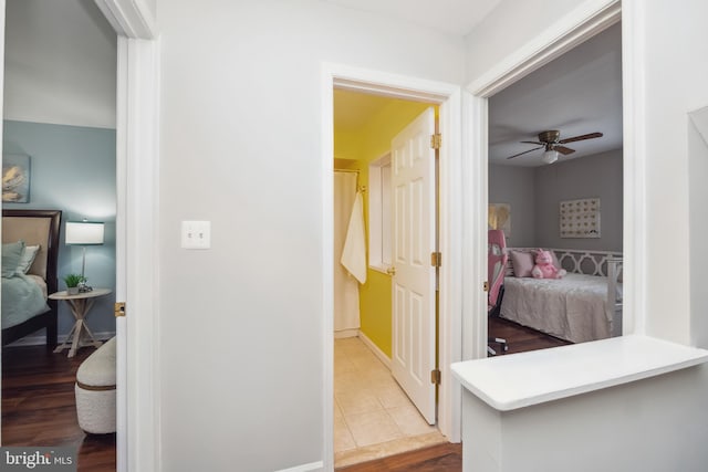 hall featuring baseboards and wood finished floors